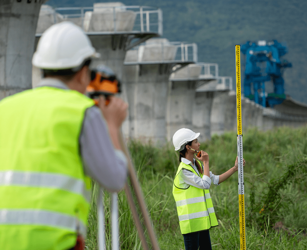 Workers in helmets with surveying tools