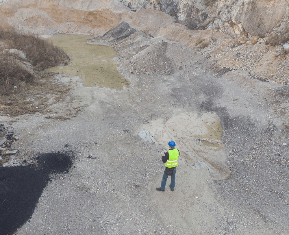 Worker surveying rocky landscape