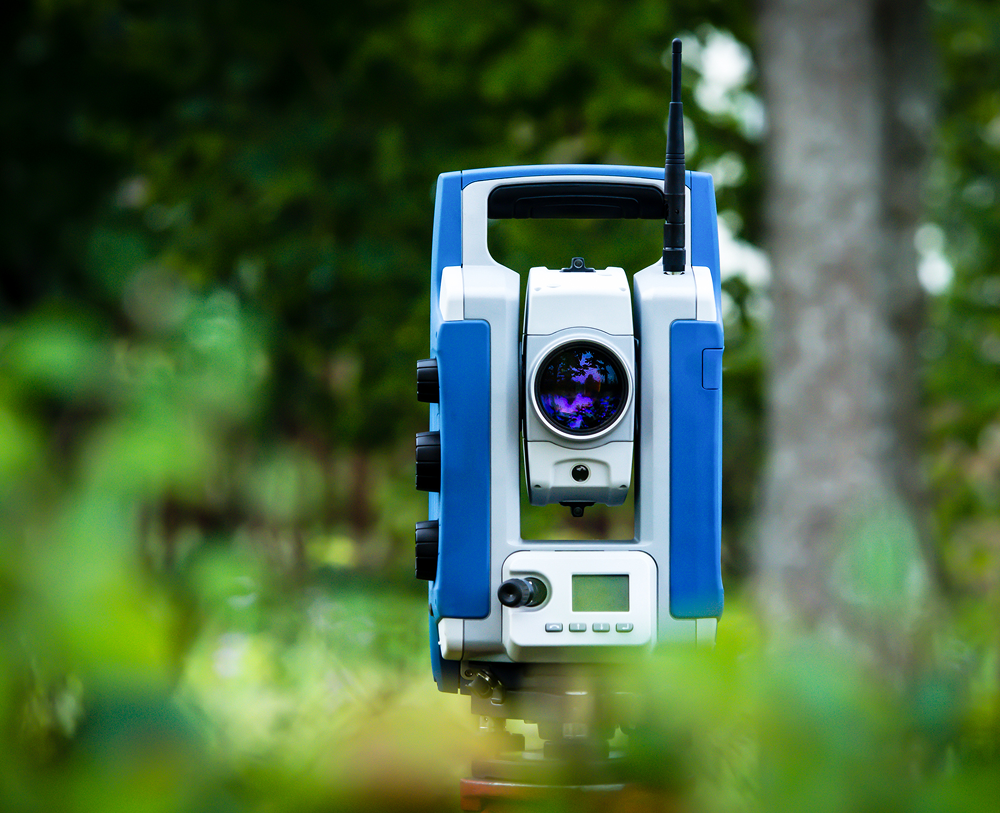 Surveying instrument in a green landscape