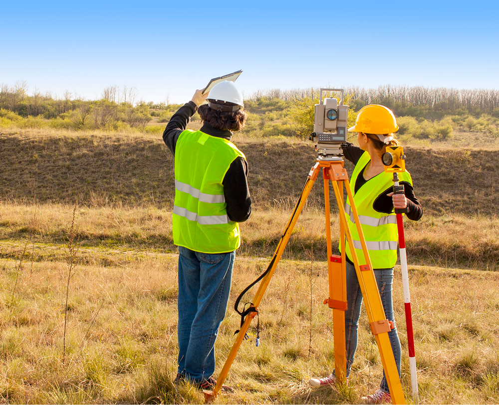 Engineers using surveying equipment outdoors