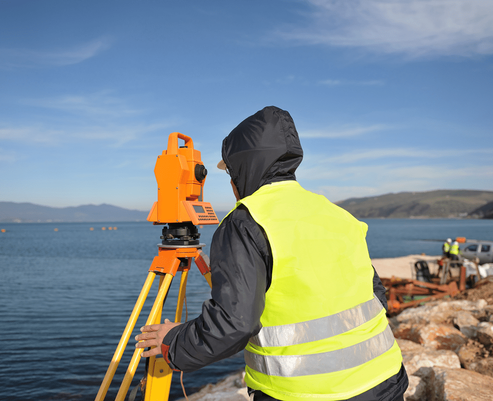 Engineer using surveying equipment outdoors