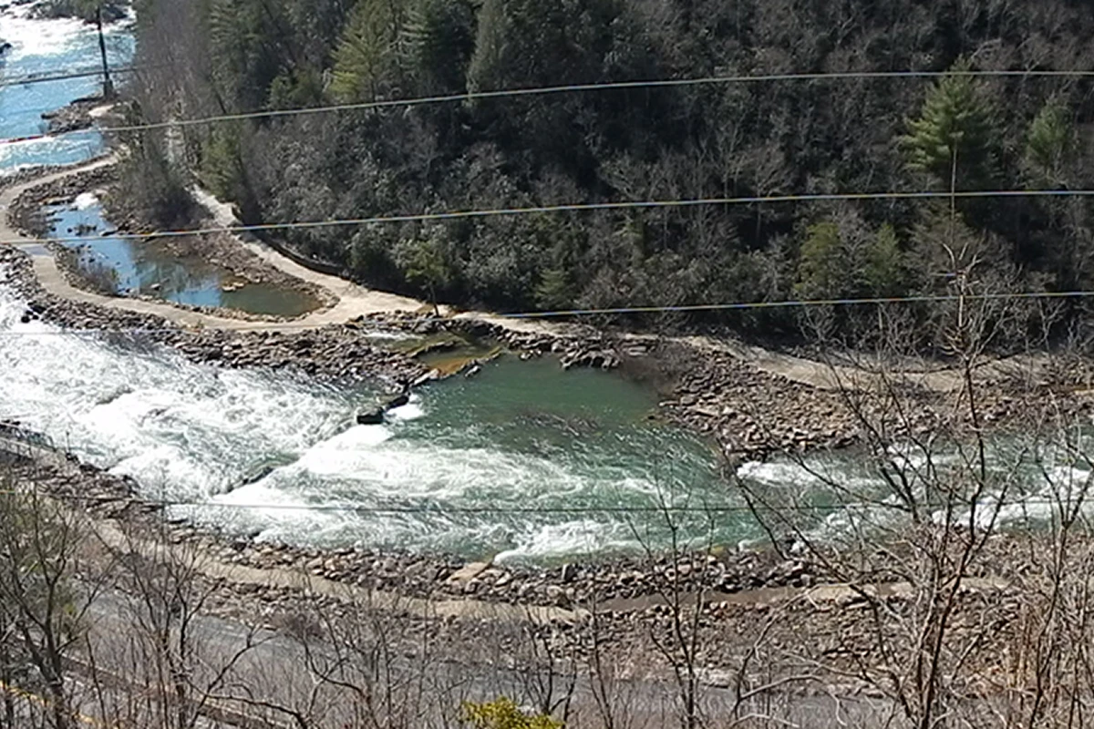 River flowing through rocky forested landscape.