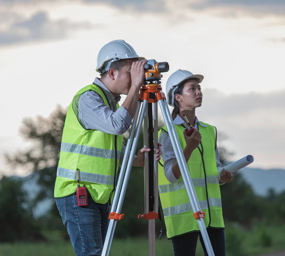 Surveyors using equipment on a construction site.