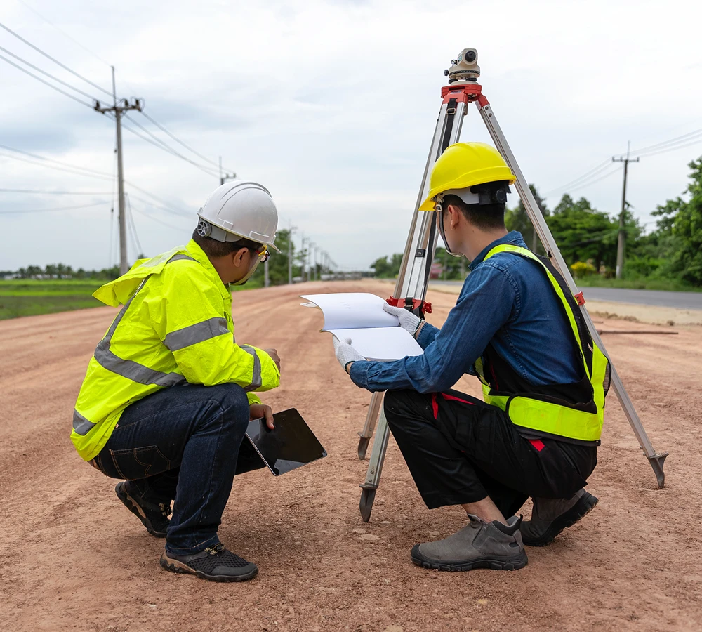 Surveyors examining plans on a construction site.