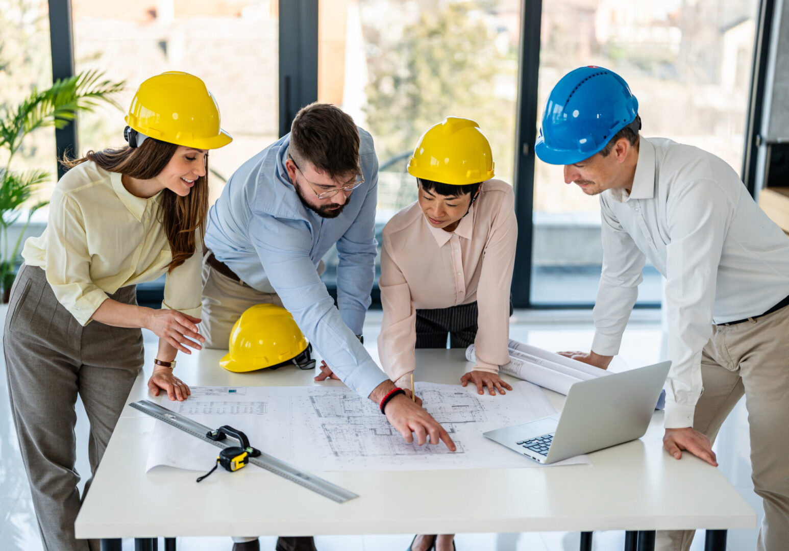 Engineers reviewing blueprints at a table.