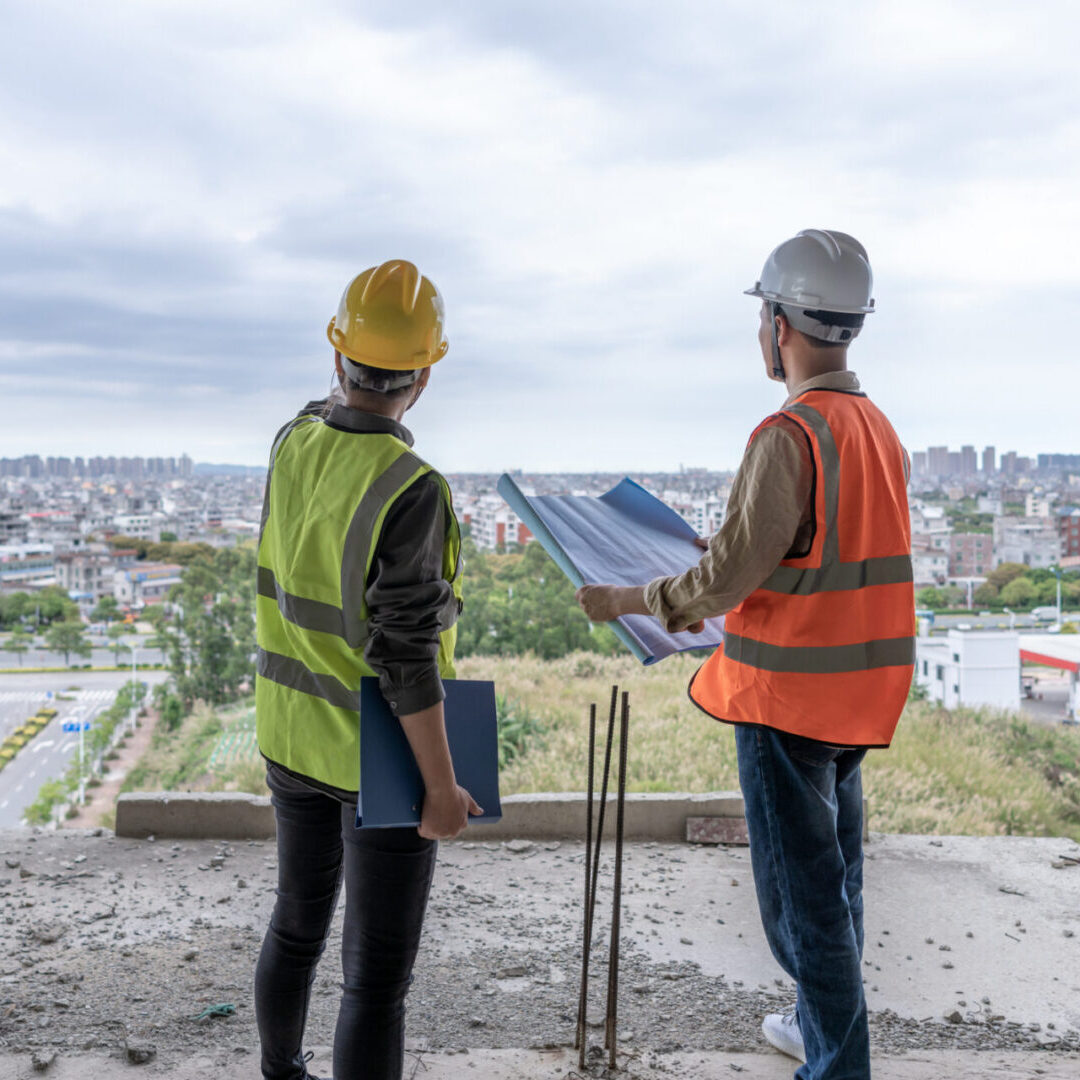 Construction workers overlooking city development site.